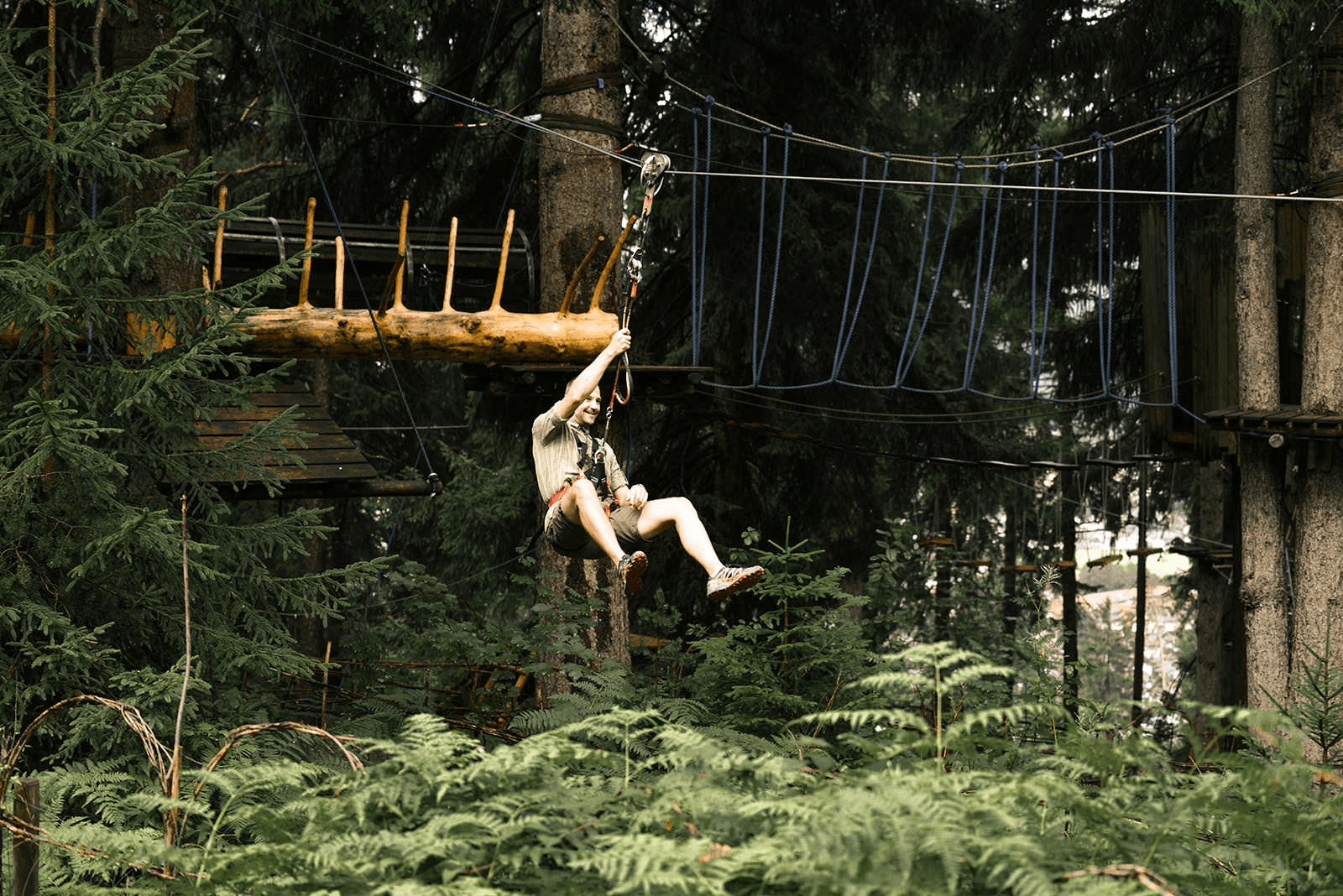 Ein Mann schwingt im Kletterwald Garmisch-Partenkirchen an einer Seilrutsche