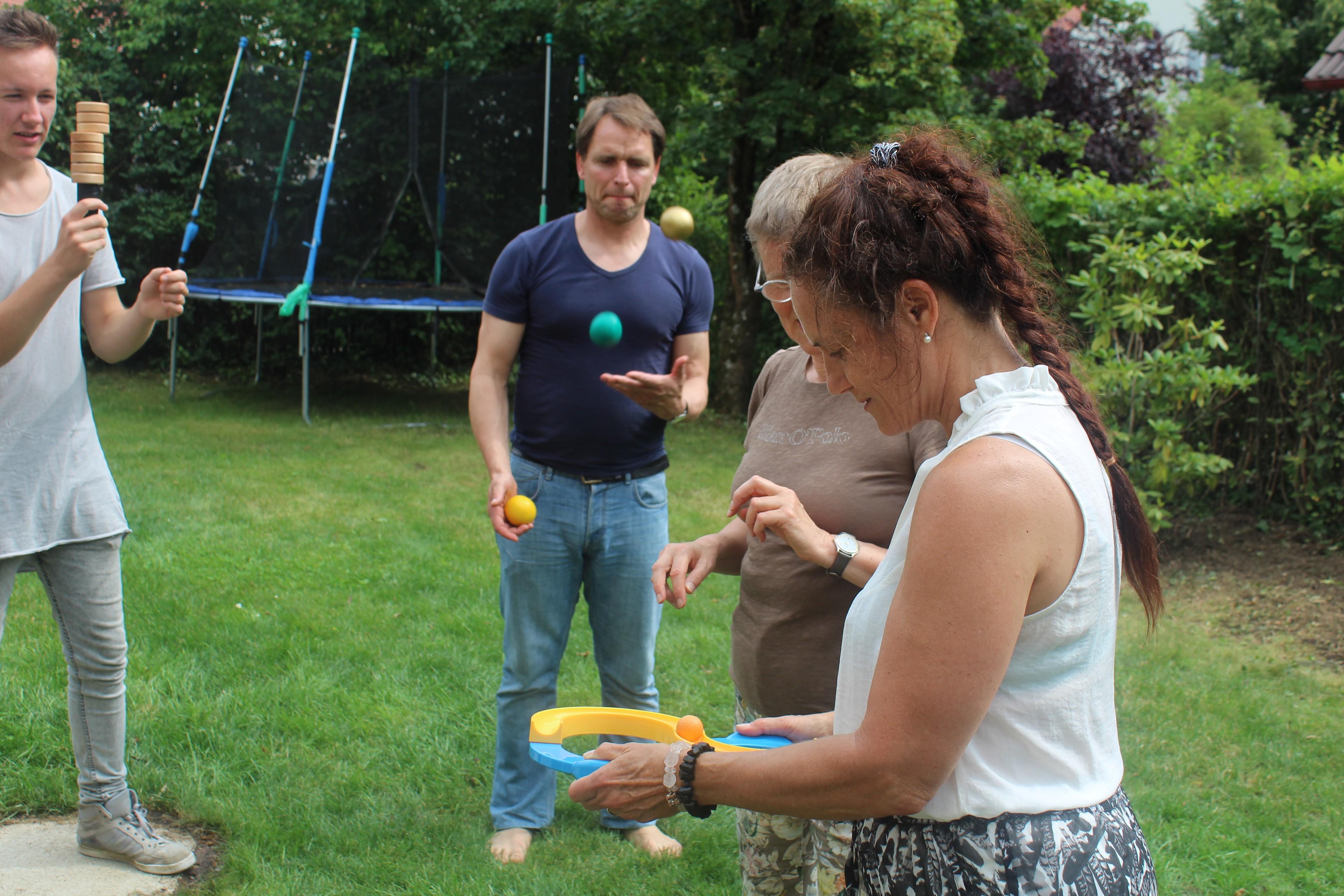 Teilnehmende eines Jonglier-Workshops werfen Bälle in die Höhe