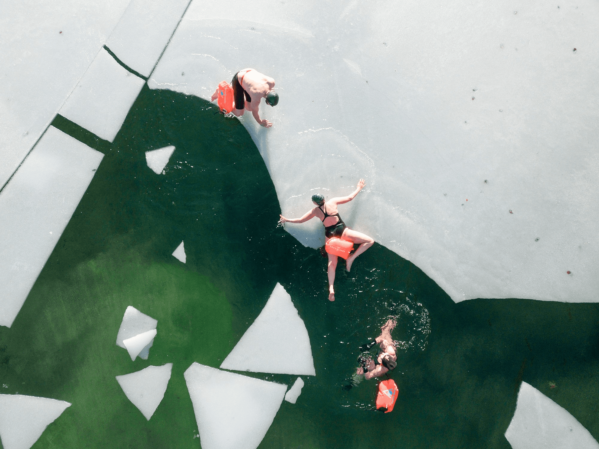 Menschen im Wasser und auf Eisschollen beim Eisbaden in Ruhpolding