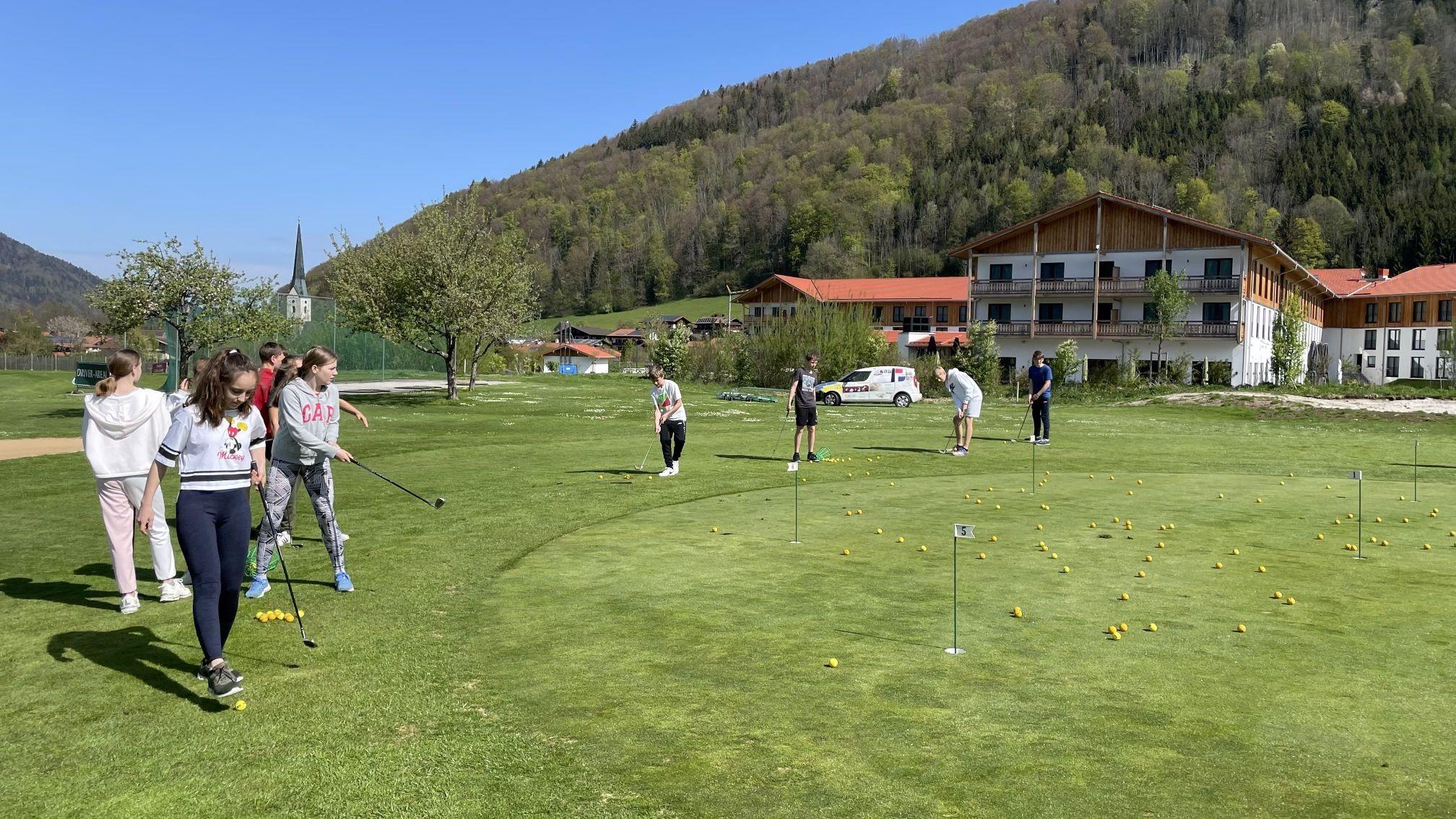 Golfer:innen üben Putten am Putting-Green