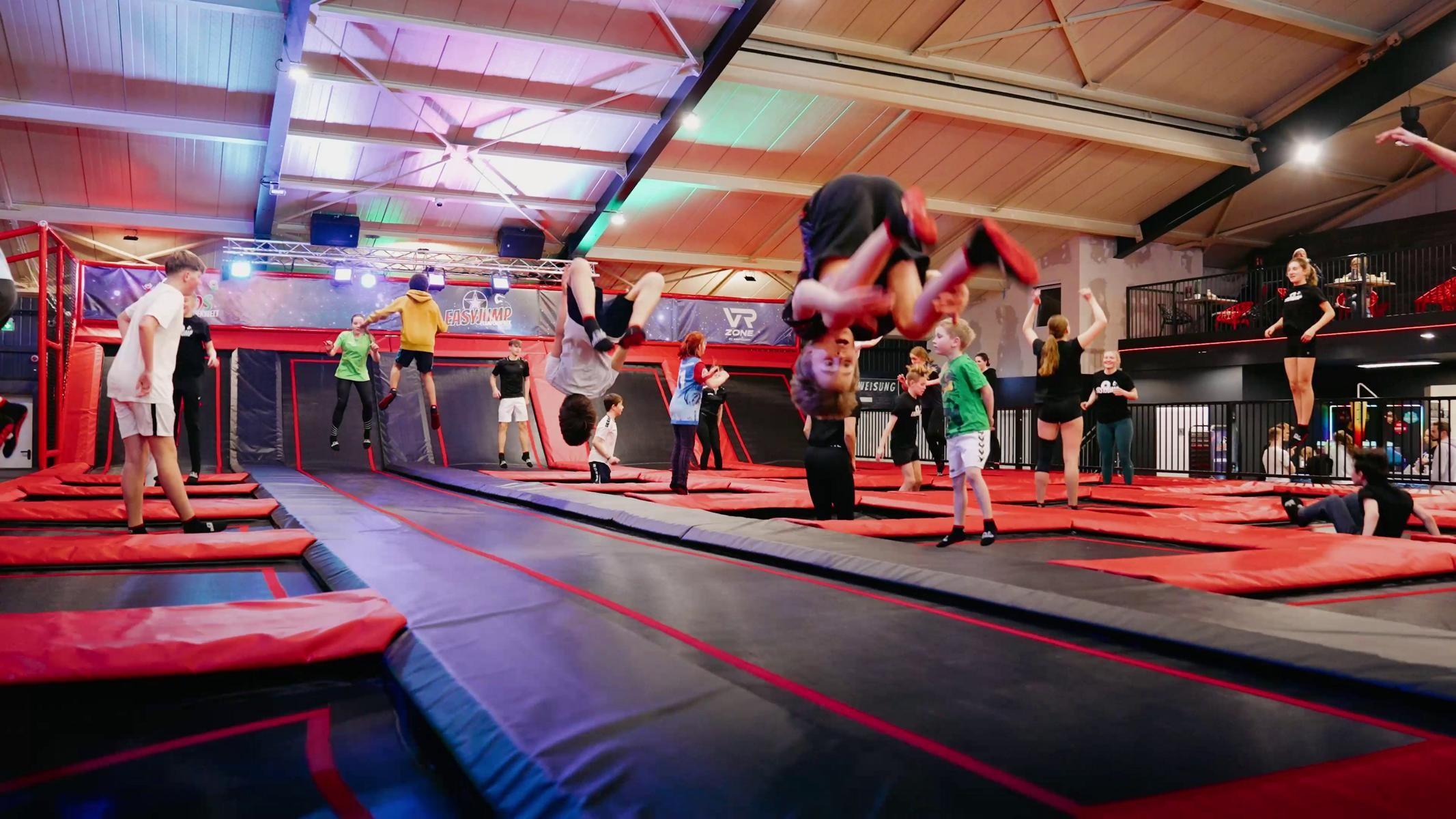 Kinder springen auf schwarz-roten Trampolinen in der Trampolinhalle EasyJump in Grömitz
