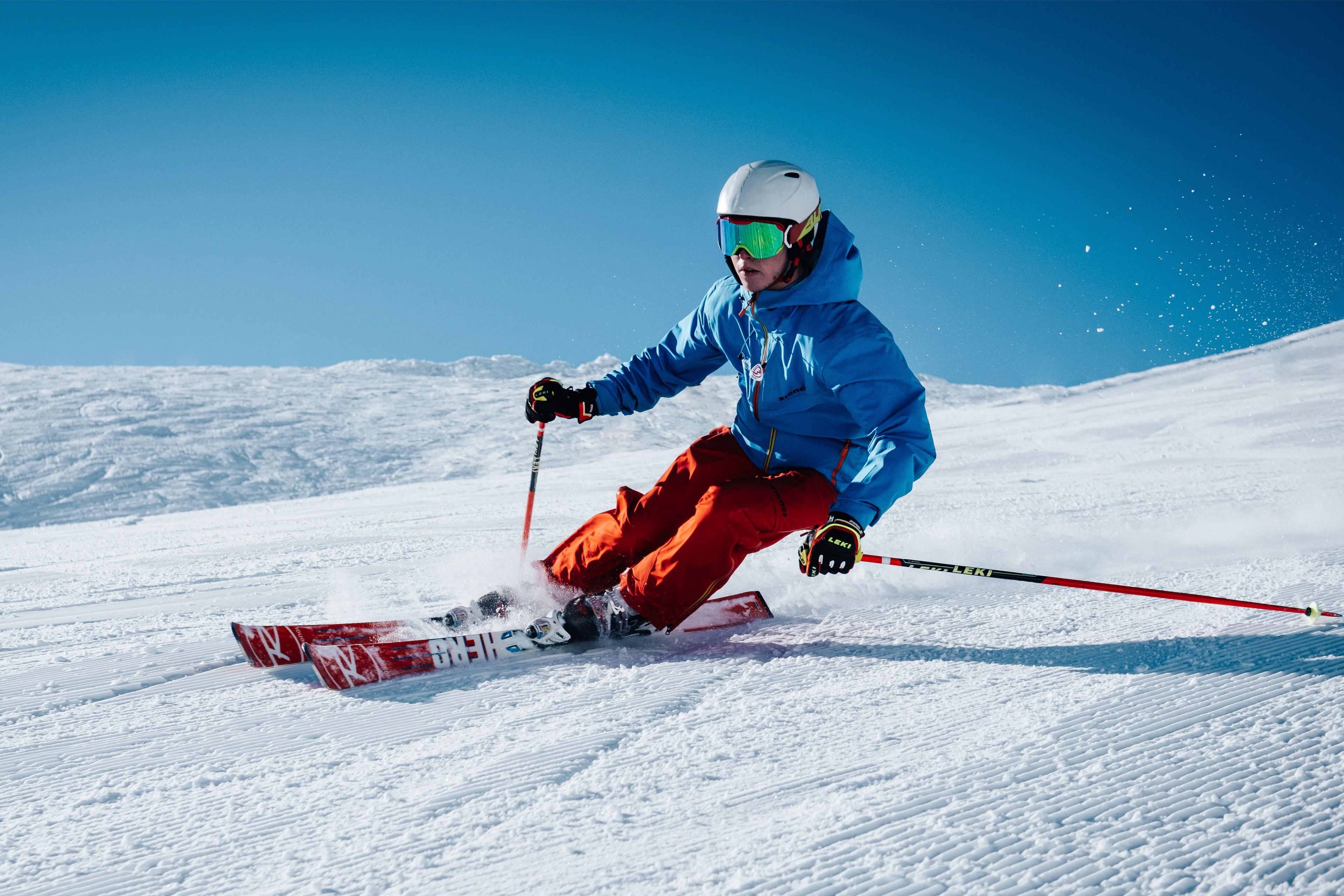 Ein Skifahrer legt sich bei der Abfahrt in die Kurve