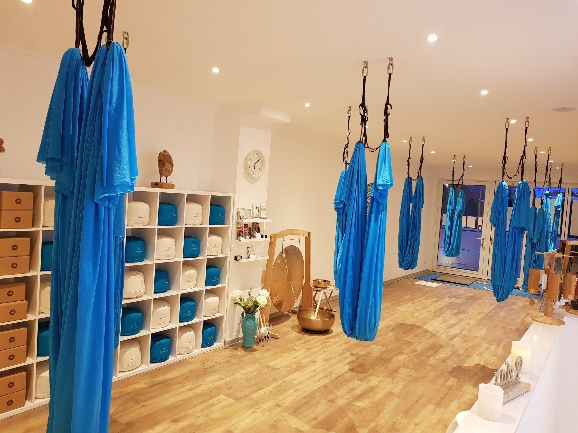 Aerial-Yoga-Tücher hängen in einem Raum von der Decke