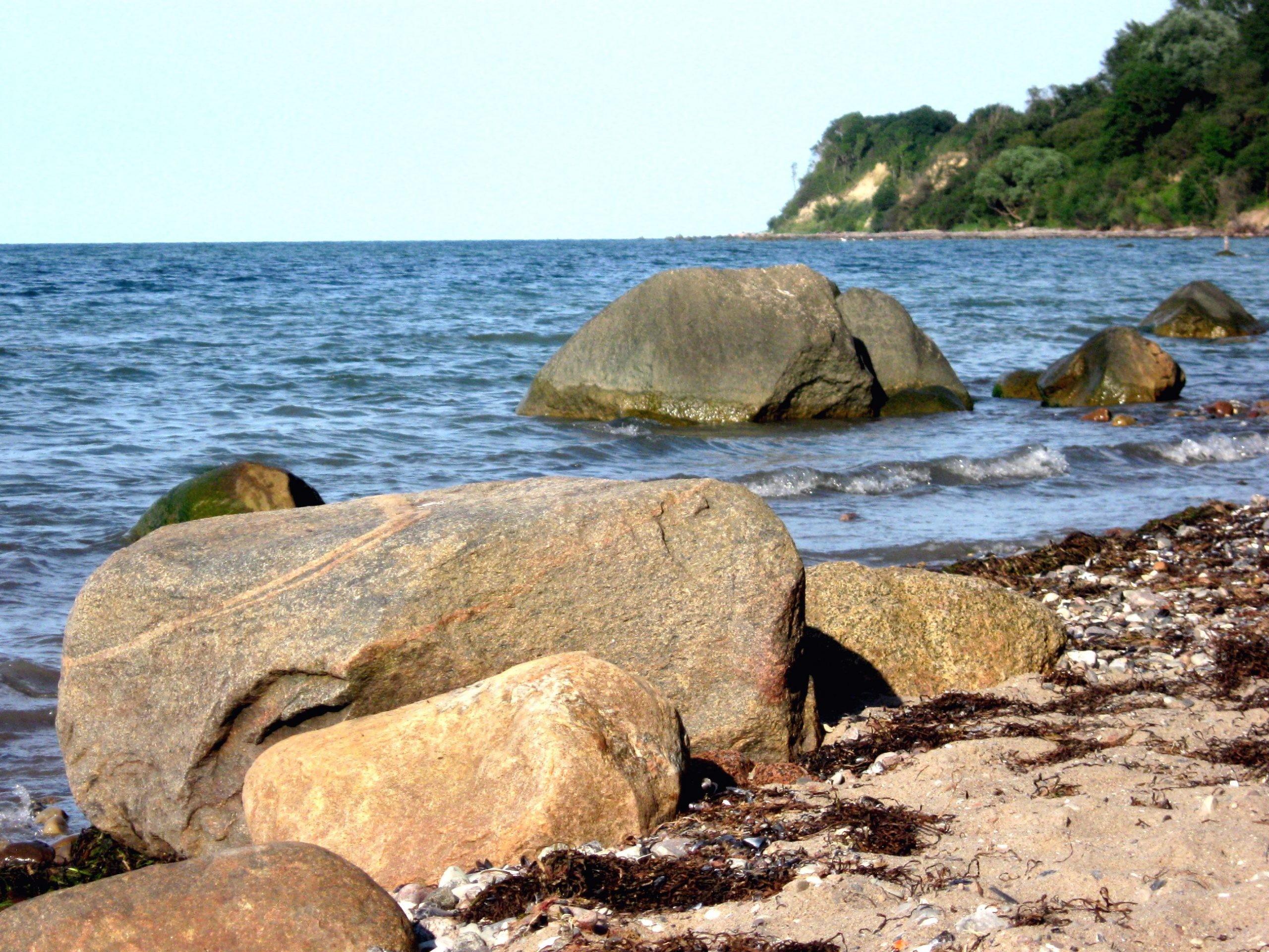 Steine an der Ostseeküste mit der Steilküste im Hintergrund