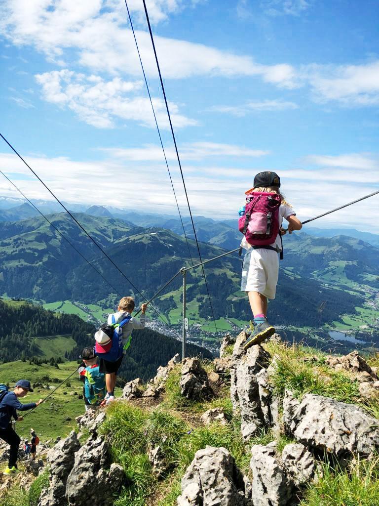 Kinder gehen einen Klettersteig bei Kitzbühel