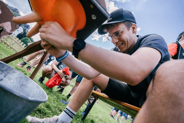 Ein junger Mann melkt bei einer „Bayerischen Olympiade“ den Euter einer Kuh-Attrappe