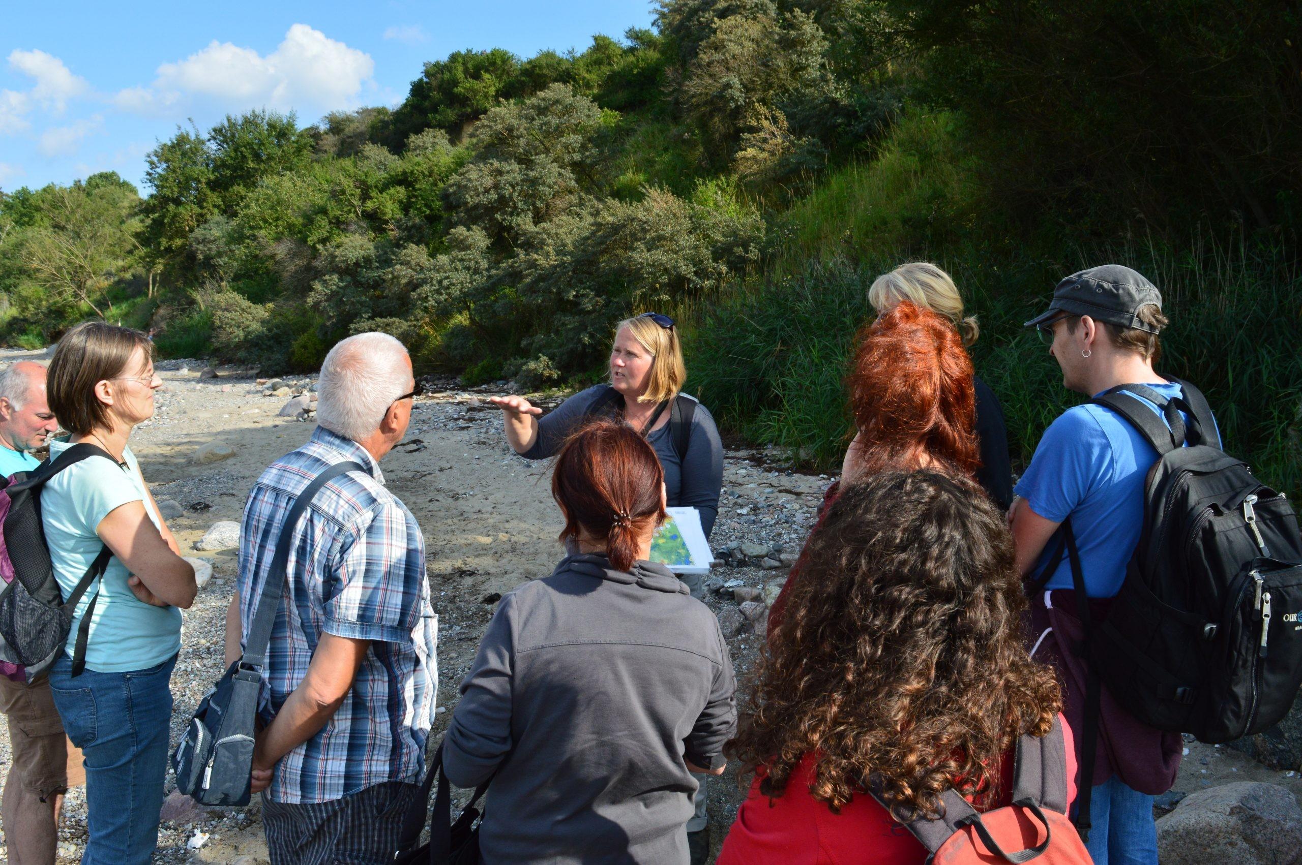 Geologin Kerstin Pfeiffer mit einer Gruppe bei einer Stein-Exkursion in Boltenhagen