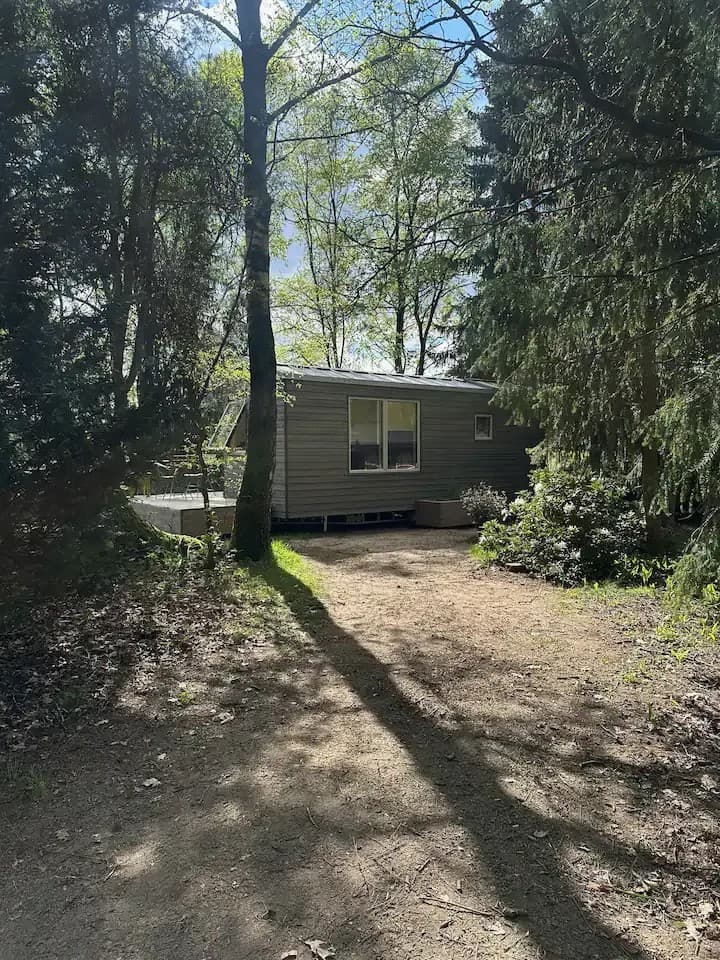 Außenansicht eines Tiny Houses in der Lüneburger Heide mit Bäumen ringsum