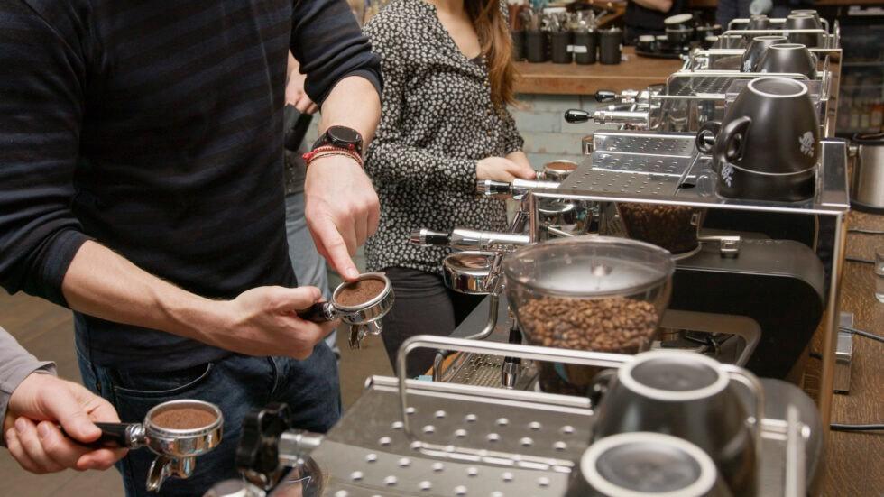 Personen üben bei einem Barista-Workshop an Siebträgermaschinen