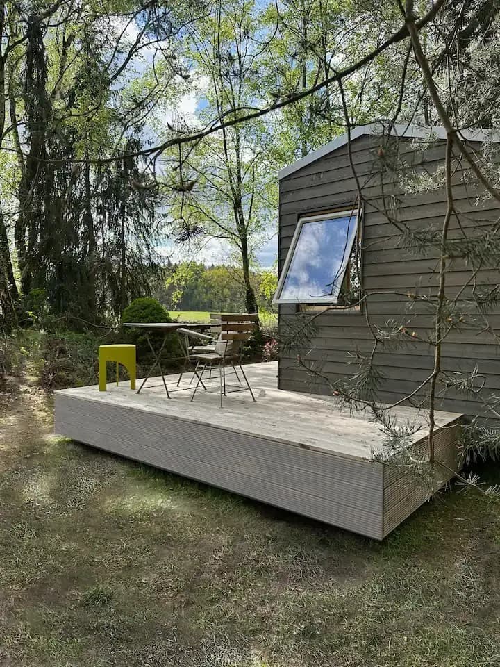 Außenansicht eines Tiny Houses in der Lüneburger Heide mit Bäumen ringsum